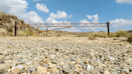 Closed gate seen from below and located in the middle of the desert.