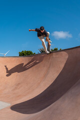 young skater wearing black tshirt skating inside a bowl in a skate park.  © magui RF