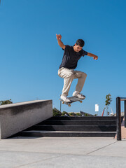 young skater wearing black tshirt jumps a staircase in a sunny day.   © magui RF