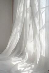 A white curtain is hanging in front of a window, letting in the sunlight
