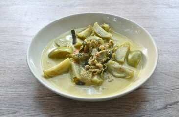 spicy boiled slice beef meat with eggplant in coconut milk green curry soup on plate
