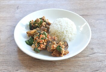 slice boiled black preserved egg dressing spicy fried chop pork meat and basil leaf on plain rice in plate