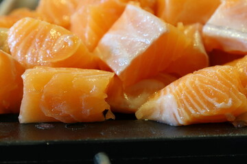 Salmon pieces. Raw fish on a black cutting board.