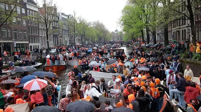 Amsterdam, Netherlands - April 27, 2024: Locals celebrating Kingsday in Amsterdam on the canals in the Netherlands