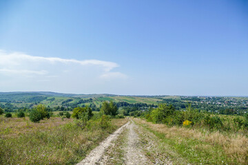 road in the field, rural houses in the distance, in the background, wildlife, mountains, trees, weeds, dry, forest, meadow, meadow, sky, clouds, summer, grass