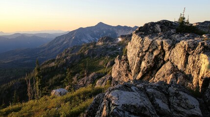 Majestic sunset view from rocky mountain peak, showcasing layered mountain ranges, evergreen trees, and a dramatic sky.