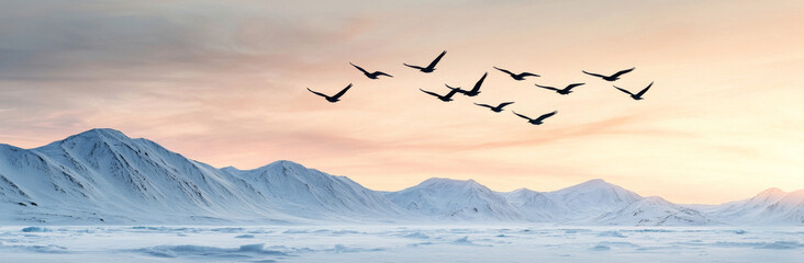 Fototapeta premium Flying birds over snowy mountains at sunset create serene landscape