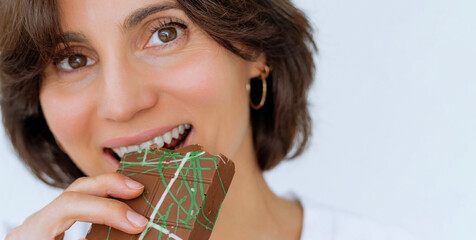 Close up of woman portrait eating Dubai chocolate with green pistachio paste, cream and kataifi...