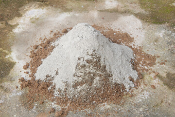 pile of sand with dry powdered cement poured on top outdoors, step preparing concrete in selective...