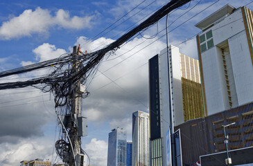 pylon covered with electric wires connected to new buildings in Phnom Penh, Cambodia