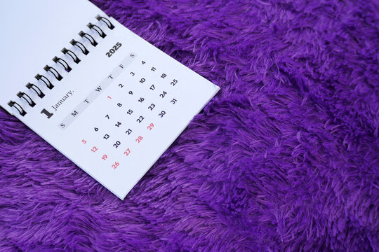 January 2025 desk calendar on purple furry fabric