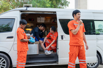 back view of paramedic team move accident patient suffered on leg to ambulance after first aid help and refer to hospital © Verin