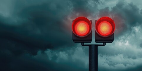 Two red traffic lights against a dark, cloudy sky, signaling a stop and indicating caution in the environment.