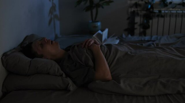 Man sleeping and snoring in a cozy bedroom, briefly waking himself with his snore before drifting back to sleep. Nighttime atmosphere of a comfortable home.
