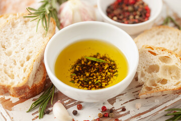 Bread dipping oil. Crusty bread ciabatta and bowl of olive oil with spices.