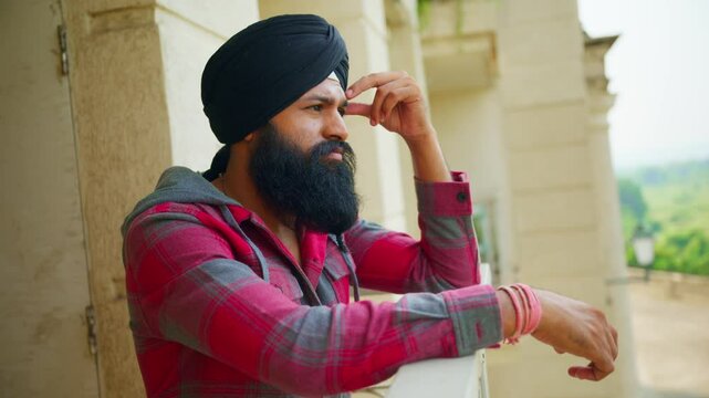 Thoughtful sikh man wearing Headscarf stands over gallery