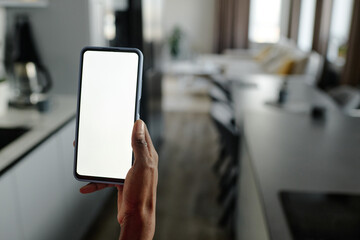 Medium close up of unrecognizable female hand holding smartphone with white screen in blue case