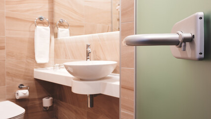 A bathroom with a white sink and a green door. The door is open and the sink is in the foreground