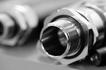 A silver pipe with a small hole in the middle is bent and has a small hole in the middle. The pipe...