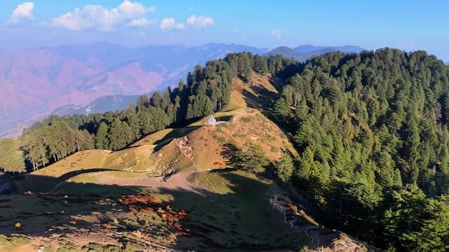 sunshine glowing on mountain peaks under a cloudless blue sky, highlighting the serene natural beauty of Chakrata's rugged landscape.