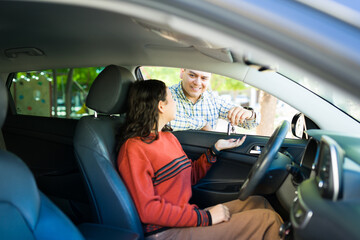 Proud father handing over car keys to his teenage daughter, symbolizing trust, responsibility, and a new chapter of independence as she learns to drive