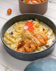 Fettuccine Alfredo with chicken sliced ​​steak. creamy sauce and pasta And grated cheese and Mushrooms create an appealing presentation for restaurant .