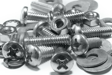 Close-up of various metal fasteners including phillips head screws, nuts, and washers