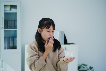 Young Asian girl is saving money for the future. Doing so will help her achieve her financial goals and create financial security.