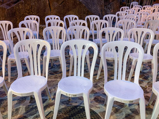 Rows of plastic chairs set up for an outdoor concert