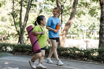 Obraz premium Petite Woman and Friend Enjoying a Morning Jog in the Park Surrounded by Nature and Fresh Air
