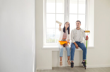 Positive and happy family couple dreaming together while renovating and painting new home. Embrace creative ideas, planning construction and personalizing space during the building process.