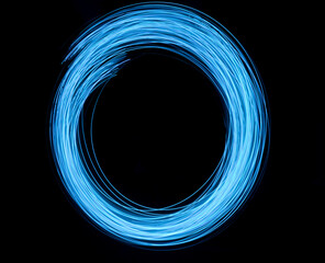 A long exposure photograph. Light painting photography with vibrant electric blue lights against a black background.