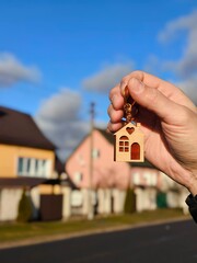 The concept of buying an apartment. Man holds the keys to the house in his hands against the...