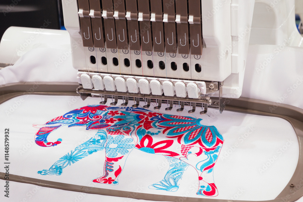 Fototapete a machine is embroidering a design of an elephant. the machine has a lot of buttons and a lot of thr