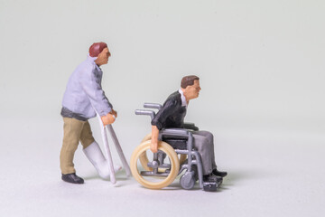miniature figure concept of disable people	