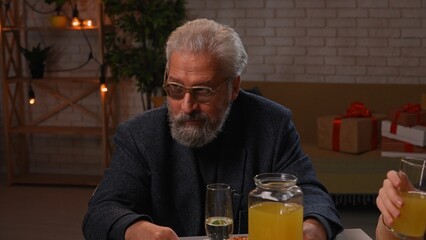 Family sit at table at home, grandchildren and parents celebrating birthday of grandfather, family members enjoying meal, close up of grandpa.