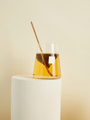 tea bags brewed in a glass, in a beautiful minimalist composition on a beige background