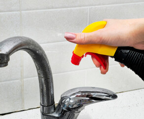 Female hands with cleaning agent. Kitchen cleaning, kitchen faucet.
close-up of woman's hand and cleaning