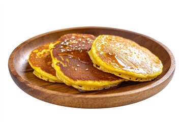 Three golden pancakes drizzled with syrup on a wooden plate.