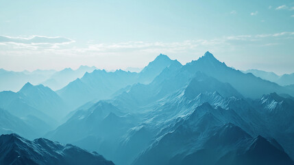 Obraz premium Majestic mountain range under a blue sky with soft white clouds in the distance.