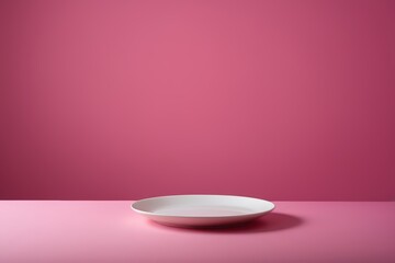 a white plate on a pink surface
