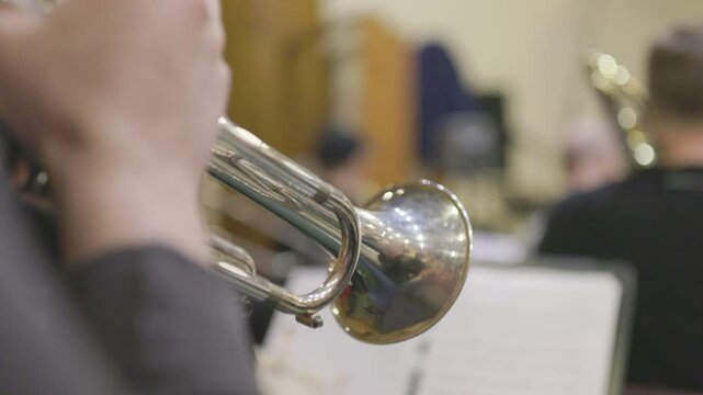 A shot of a trumpet player from the back with only the trumpet and his hands being visible during a big band practice session. Nr.2