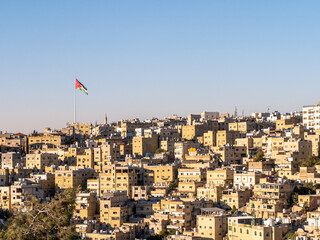 Jordanian flag flying high over Amman, Jordan during sunset - Landscape shot