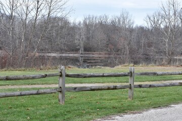 Fototapeta premium park scenery picnic table winter trees lake fence background