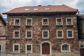 Summer landscape with old stone house on city street in Austria