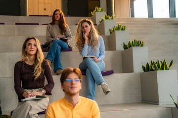 Students taking notes and listening to presentation in modern university hall
