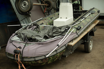 Boat on trailer. Inflatable boat in garage. Water transport.