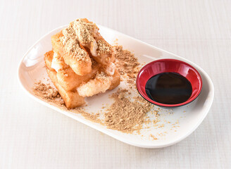 Brown sugar glutinous rice cake with soy sauce served in tray dish isolated on white background side view of hong kong food