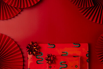 Chinese New Year theme with red paper fans and gift boxes. Year of the Snake.