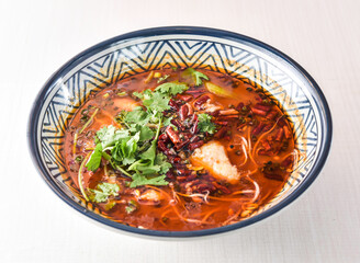 Sichuan Boiled fish with red chilli, noodles, green onion, potato powder and coriander served in bowl isolated on white background side view of hong kong food